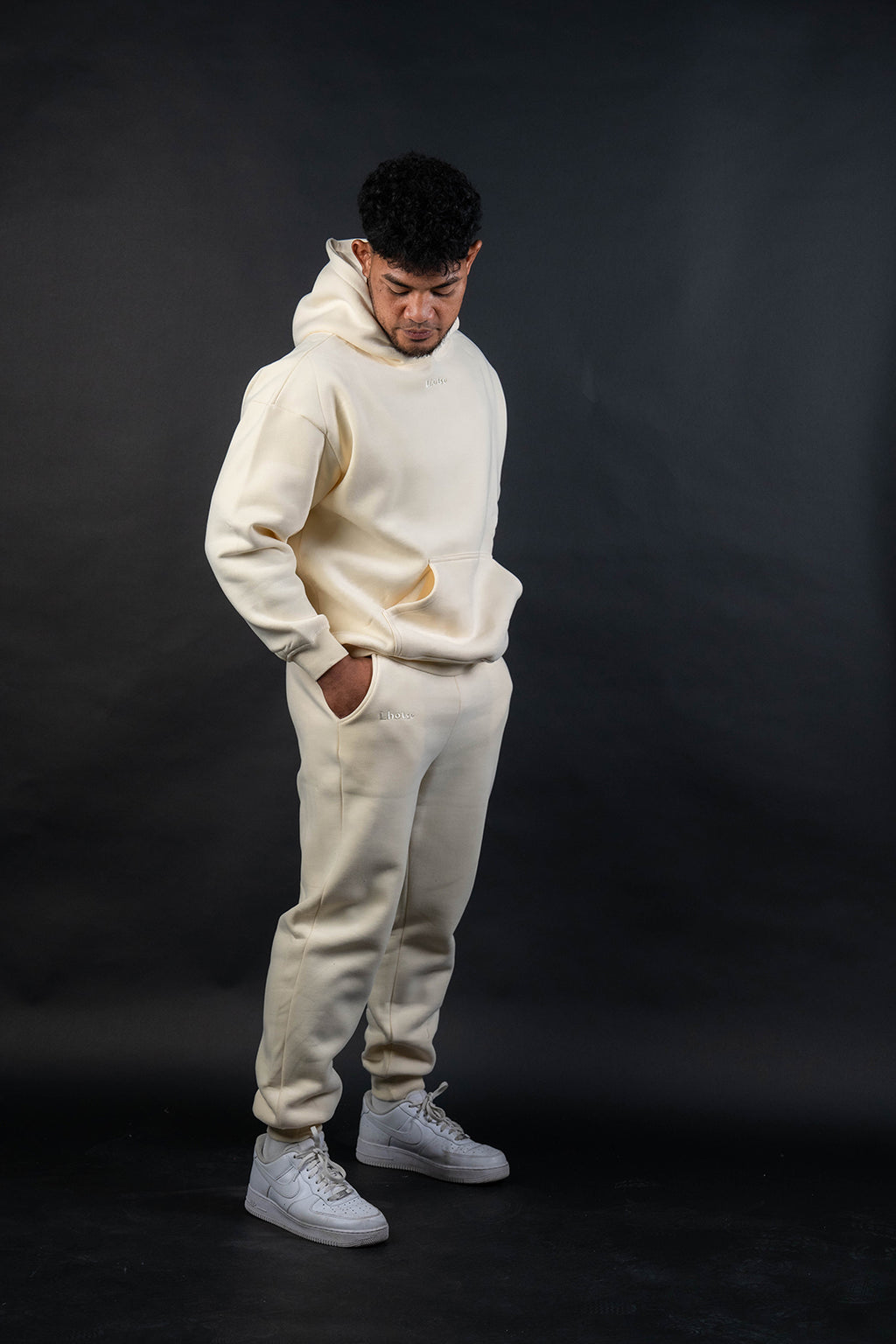 Person wearing a white tracksuit against a black background